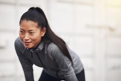 Focused woman in workout gear leaning down