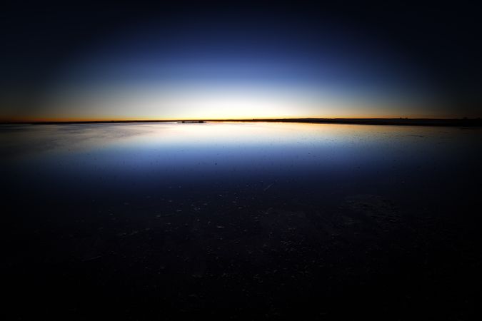 Tranquil blue water surface in dark sunset