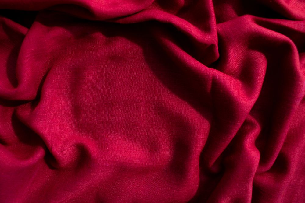 Red fabric wavy crumpled background texture with copy space.