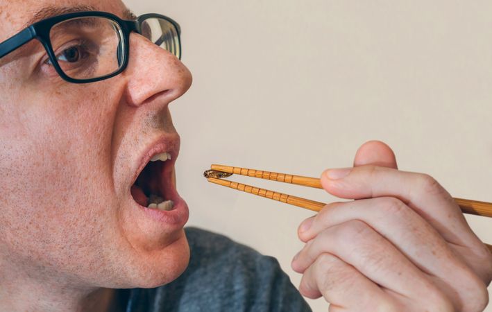 Man eating a cricket