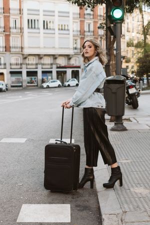 Cheerful female tourist crossing street