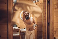 Bearded man throwing towel after bathing