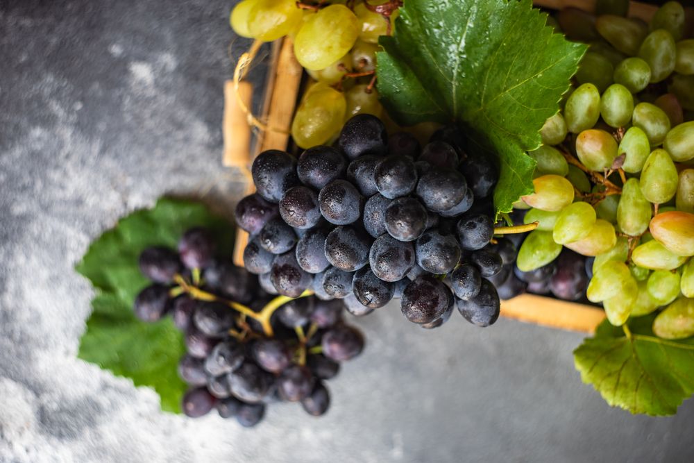 Close up of box of fresh green & red grapes in kitchen