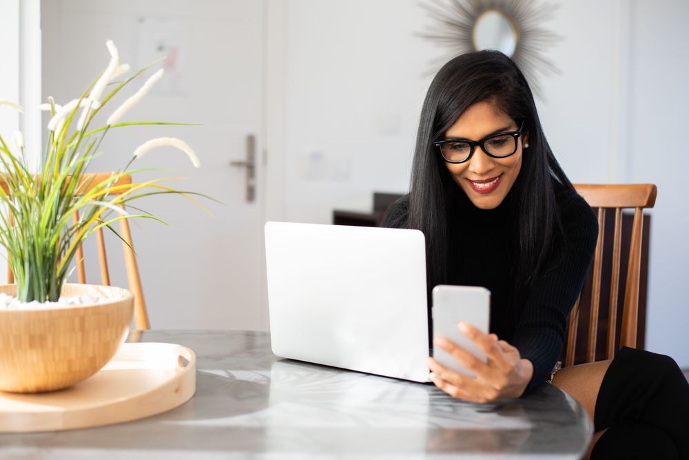 Businesswoman working from home on her computer and speaking on the mobile phone