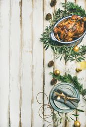 Roast chicken, table setting, decorations of festive fir, on a light background, copy space