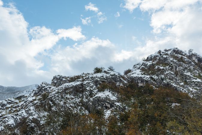 Snowy mountains under sky with clouds