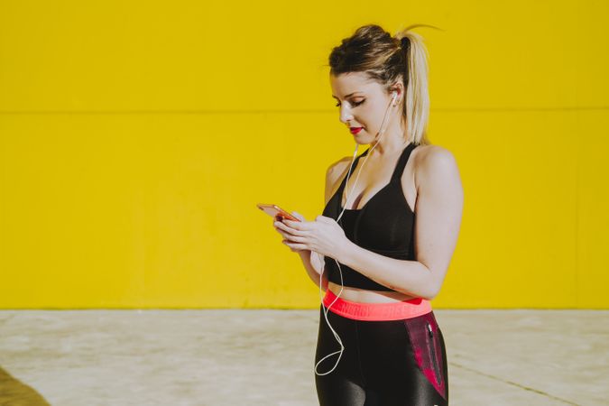 Woman with earphones using smartphone