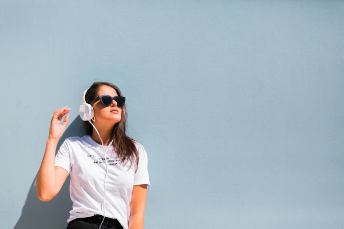 Cheerful casual woman in sunglasses standing on city street