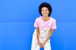 Hapy woman leaning forward in floral overalls