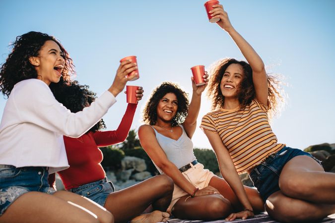 Group of women sitting together with cola drinks