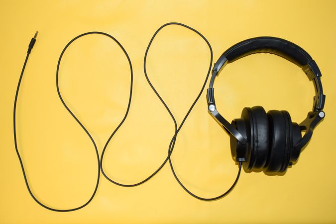 Headphones and cord on yellow background