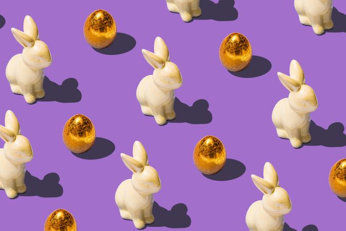 Pattern made with golden Easter eggs and bunny rabbit
