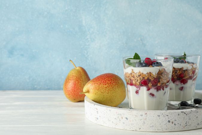 Parfaits and pears on wooden table, space for text