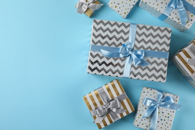 Different gift boxes on blue background, copy space