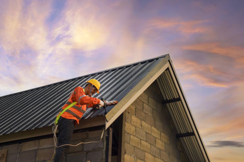 Man drilling a screw on a rooftop of a building