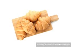 Top view of cutting board with croissants isolated on plain background 56p9Vb