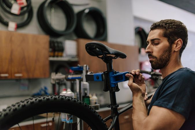 Worker with a beard concentrating on repairing a bicycle