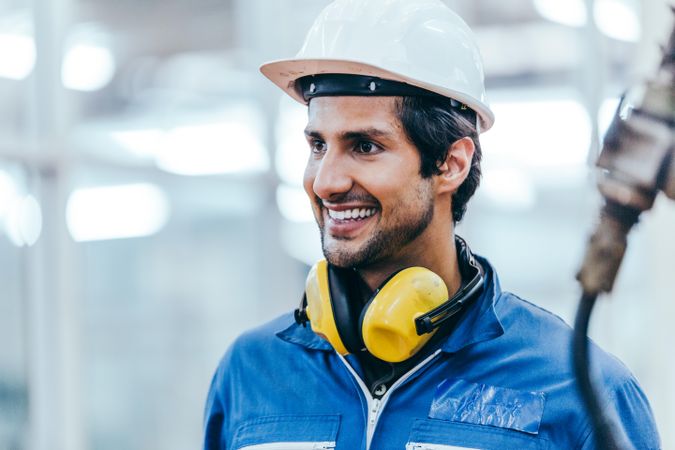Portrait of smiling industrial engineer worker wearing safety helmet