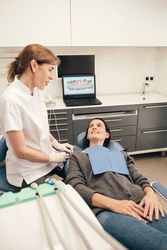 Female dentist talking to patient during appointment in clinic