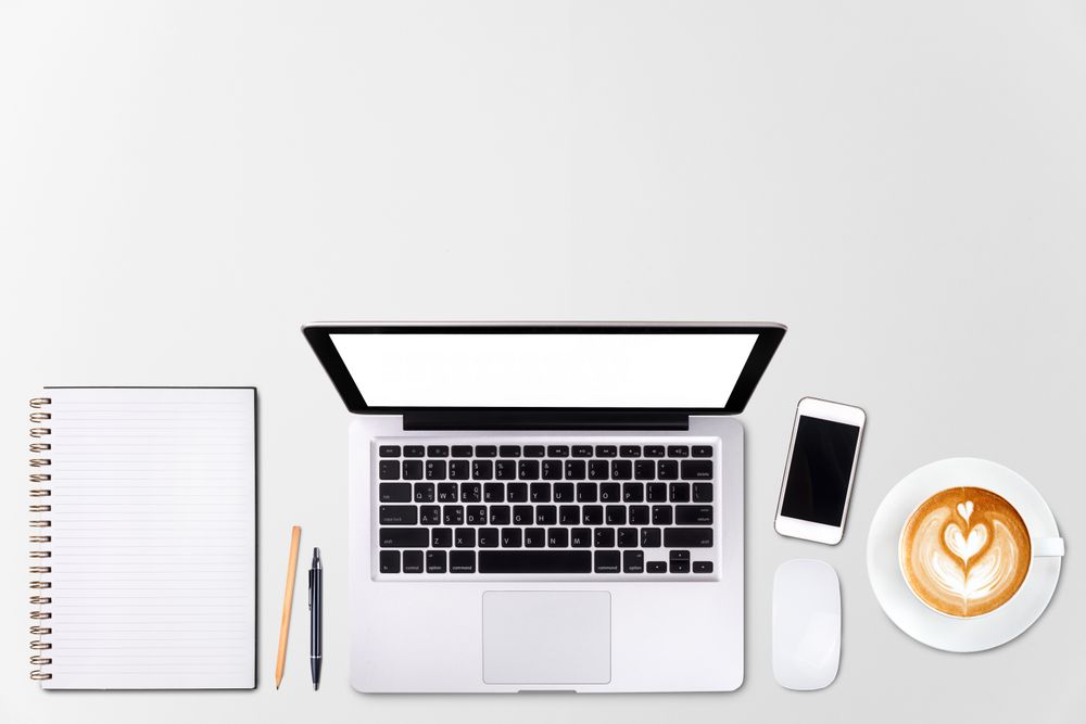 Top view laptop computer or notebook, mobile phone and cup of latte art coffee on wooden table