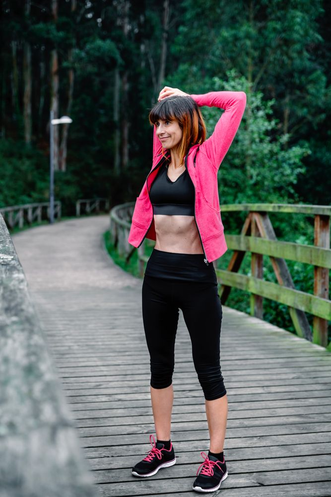 Sportswoman doing stretching arms outdoors
