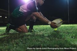 Rugby player placing the ball on tee for penalty shot during the game 5RAq20