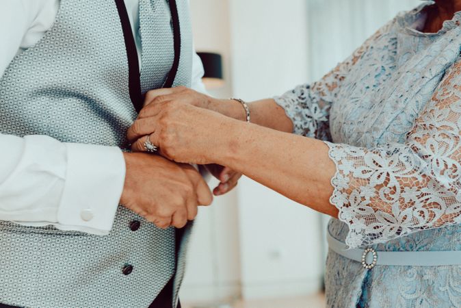 Woman buttoning up man waistcoat