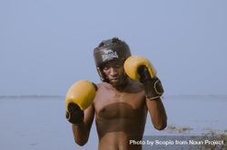 Man in wearing boxing gloves standing near lake in Accra, Ghana 5av6P4