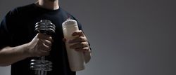 Man holding dumbbell and water bottle