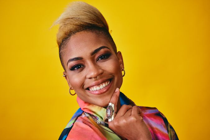 Studio shot of confident Black woman in bold 80s windbreaker jacket with hand on chin