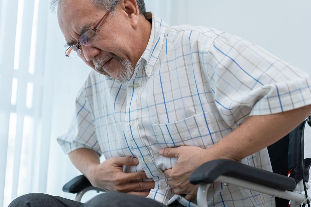 Mature male with his hand holding his stomach in pain