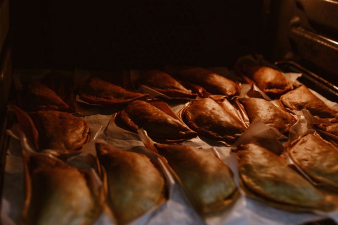 Baking tray with composed freshly baked pies patty
