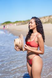 A Woman in a Stylish Swimsuit Enjoying an Amazing Day at the Beach with Vibrant Sunshine