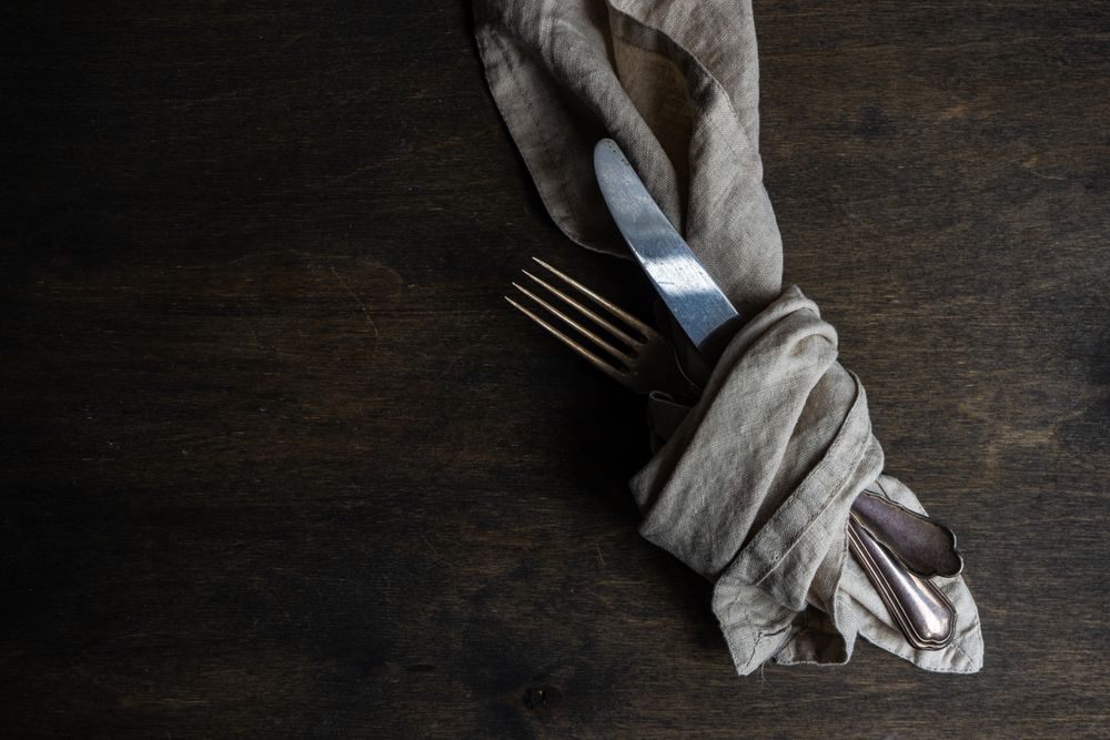Rustic table setting with grey napkin in cutlery