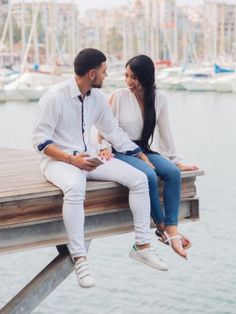 Man and woman sitting on dock with feet