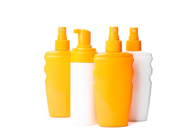 Many different sunscreen sprays isolated on plain background. Summer vacation accessories