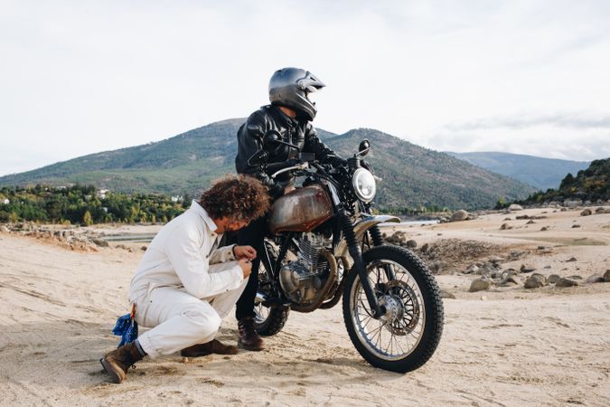 Mechanic checking motorcyclist bike engine