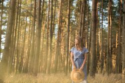 Smiling young woman relaxing among pine trees