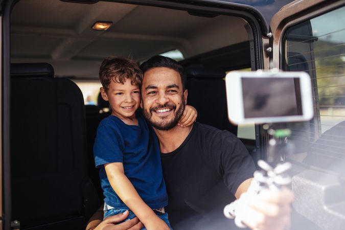 Father and son on road trip taking selfie
