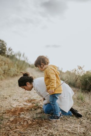 Mother and daughter looking at plants on a fall walk