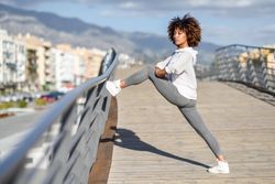 Woman warming up her legs on bridge before workout
