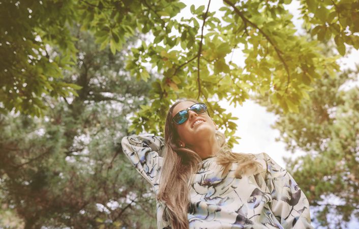 Woman with sunglasses touching over nature background