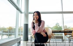 Portrait of attractive young businesswoman sitting on chair in office 4BkNkb