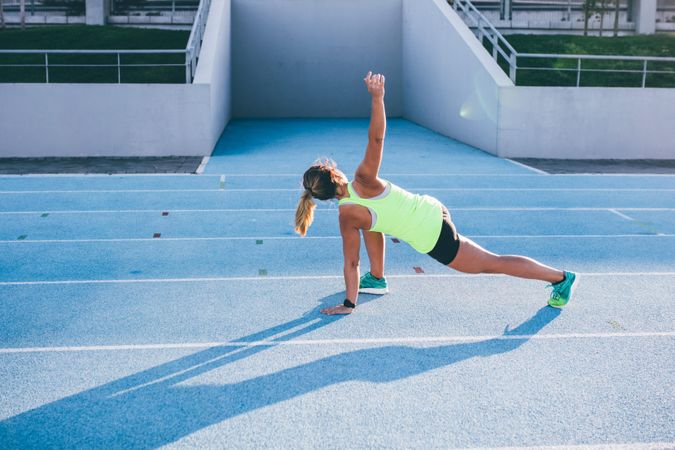 Young woman stretching on a track field