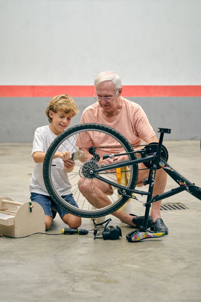 Grandson repairing bicycle with grandfather
