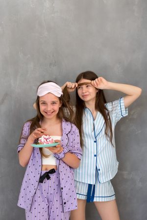 Two girls enjoying a sleepover party in colorful pajamas.
