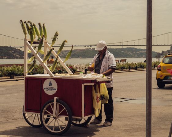Man selling corn on a cart near seashore