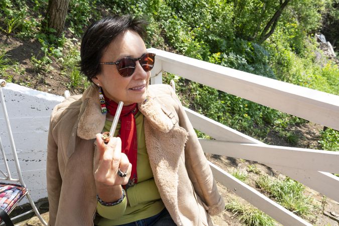 Mature woman with pipe outside