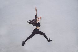 Woman jumping high along wall