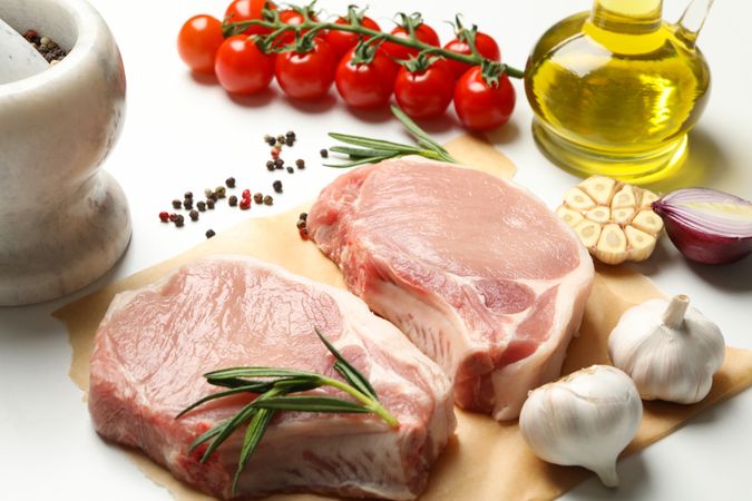 Composition with raw meat for steak and ingredients on light background